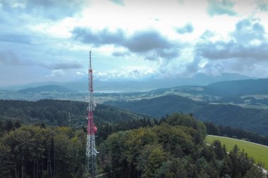 3G, 4G ve 5G tekrarlayıcıları için büyük bir anten direği ormanın ya da doğanın ortasında. Vahşi doğada tartışmalı bir teknoloji. Panoramik görünüm.
