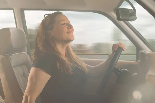 Kobieta Patrzy Lusterko Wsteczne Uśmiecha Się Podczas Jazdy Samochodem — Zdjęcie stockowe