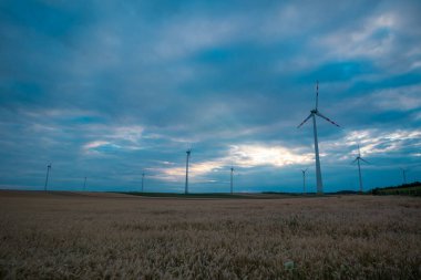Avusturya 'da geniş bir alana yayılan elektrik jeneratörü rüzgar türbinleri doğada renkli bir gecede Viyana' ya yakın..