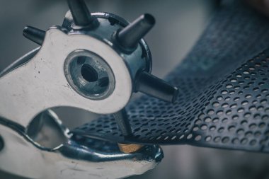 Dönen bir merkez yumruk ya da deliğin ayrıntılı görüntüsü. Zanaatkar malzemede delikler açmak için bir yumruk aleti kullanıyor. Ev işi Macro 'su..