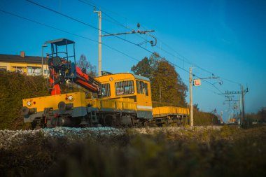 Sarı iş treni hafif bir virajda, tren raylarını tamir etmek için acele ediyor..