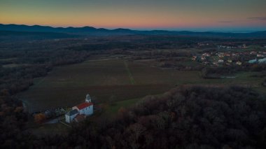 Öğleden sonra Obersjan 'daki Bakire Meryem Kilisesi ya da Karst' ın ortasında Komen yakınlarında Cihaz Marije Obrsljanske. Üzüm bağları arasında, Slovenia 'daki tipik karst kilisesi..