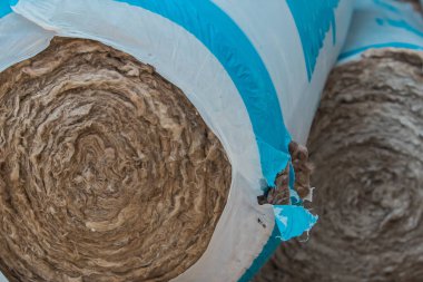 Görünür kaya yünü ya da ahşap bir evin termal yalıtımı. Vinile sarılı yalıtım rulosu.