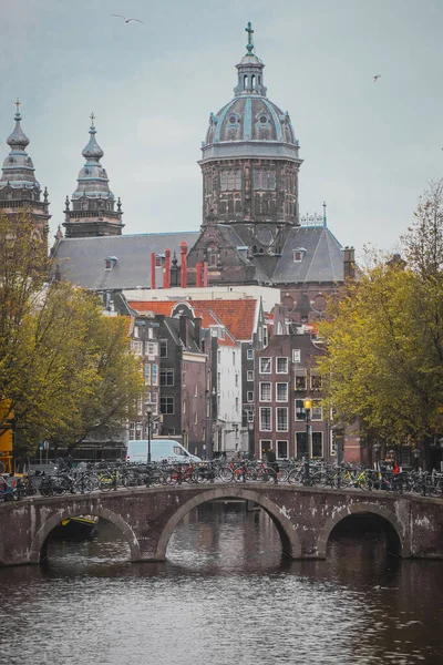 Vertikální Fotografie Kostela Mikuláše Amsterdamu Šedého Dne Výhledem Kanály Most — Stock fotografie