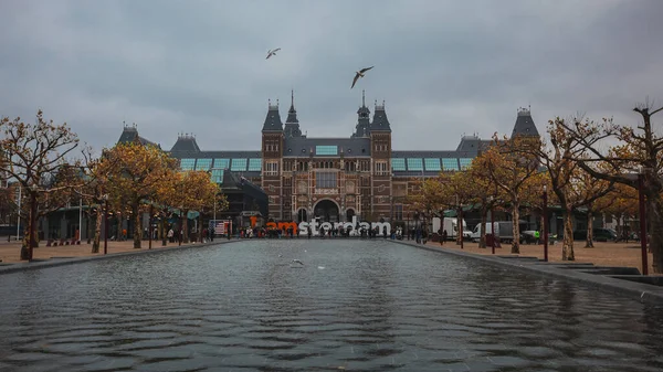 Rijksmuseum Amsterdamie Szary Dzień Widocznym Napisem Amsterdam Ptaki Latające — Zdjęcie stockowe