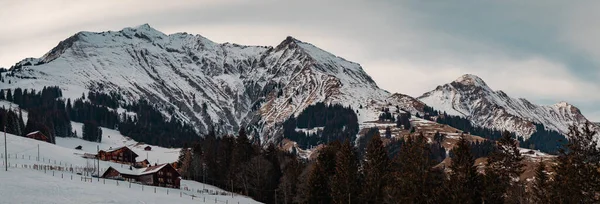 계곡과엥스 틀리겐 산비탈에 농장과 집들은 초저녁에 겨울이 됩니다 위풍당당 산에는 — 스톡 사진