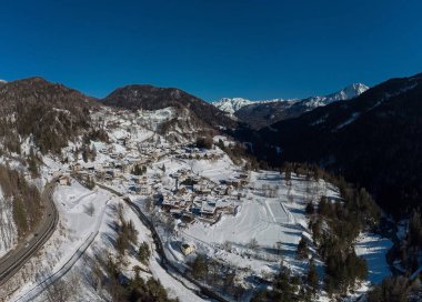 Cortina d 'Ampezzo etrafındaki vadinin hava aracı görüntüsü, güneşli bir günde Volo di Cadore köyünden karlı tepelere doğru bakıyor..