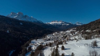 Cortina d 'Ampezzo etrafındaki vadinin hava aracı görüntüsü, güneşli bir günde Volo di Cadore köyünden karlı tepelere doğru bakıyor..