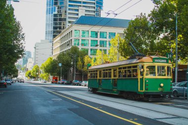 Melbourne, Avustralya 'da klasik tramvay, güneşli bir günde modern bir bölgede yol alıyor..