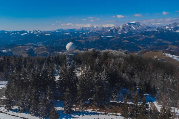 Doppler rain or weather radar on the top of the hill called Pasja Ravan in Slovenia on cold winter day. Beautiful sunny day and rain radar in between.