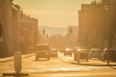 Sabahın erken saatlerinde şehrin geniş bir caddesinde trafik vardı. Güçlü arka plan ışığı.