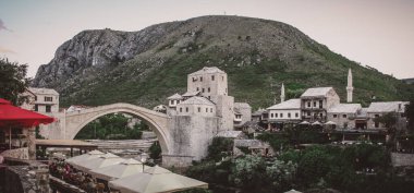 Mostar taş köprüsünün akşam atmosferindeki panoramik fotoğrafı.