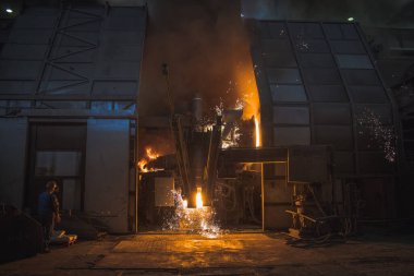 Büyük çelik fabrikası ya da demir ocağı. Demir kırıntılarından çelik üretmek için oksijen enjekte etme işlemi. Kıvılcımlar uçuşuyor ve sıcaklık artıyor.