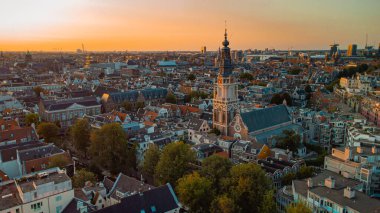 Amstedam şehrinin güzel akşam manzarası batıya doğru bakıyor güzel bir gün batımı ve Amsterdam 'da batıyor. Drone görünümü.