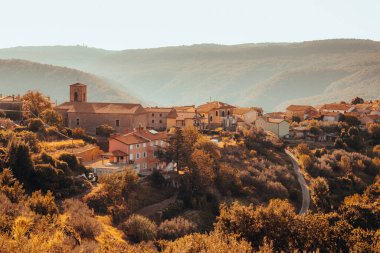 Güneşli bir günde tepedeki ortaçağ köyü olan Sloven Istria 'nın orta kesimindeki Kostabona köyüne..