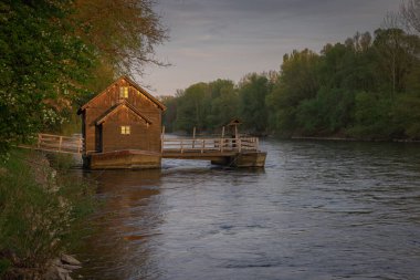 Mura Nehri 'ndeki eski güzel ahşap değirmen ya da Slovenia' nın Pomurje bölgesinde romantik bir yaz günbatımında mlin na muri.