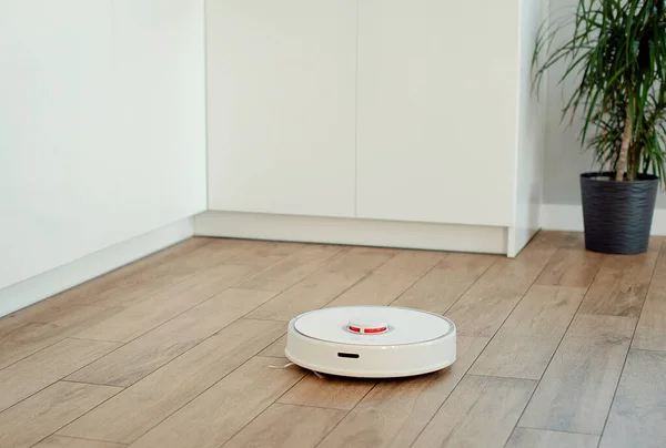 Beyaz robot süpürge yerleri yıkıyor..