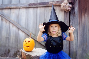 Cadılar Bayramı için bir cadı olarak giymiş küçük bir kız