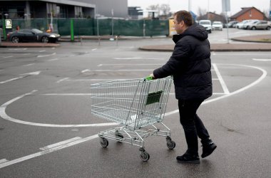 Adam alışverişini yaptı ve poşetleri bagaja koyuyor..