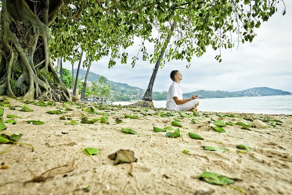 Man doing meditation exercises on the beach — Stock Photo, Image