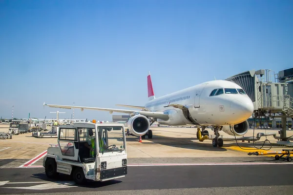 Avião no aeroporto durante o carregamento de passageiros. perto do tractor — Fotografia de Stock