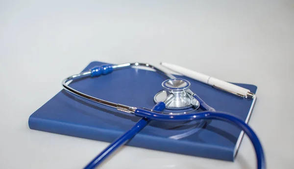 Kalem ve doktor ekipmanları ile not defterine yerleştirilmiş stonendoskop (phonendoscope)