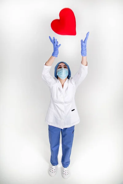 Hemşire ya da doktor üniformalı. Büyük kırmızı kalbi var.