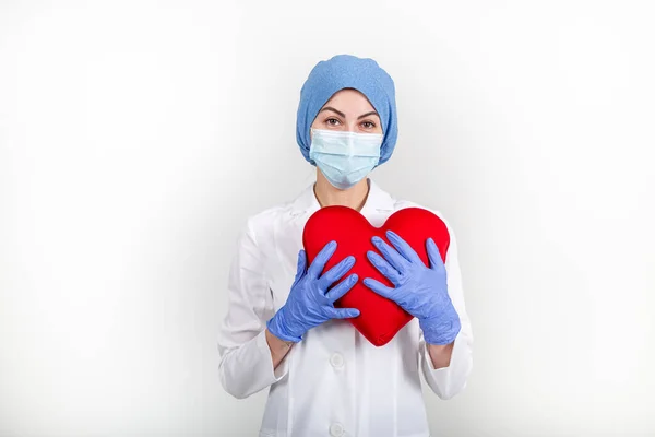 Hemşire ya da doktor üniformalı büyük kırmızı bir kalp taşıyor.