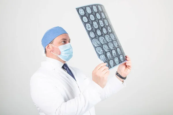 Beyaz cüppeli doktor MRI tarama izleri tutuyor.