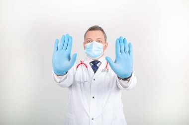 Beyaz cüppeli ve maskeli doktor. Steteskoplu ve farklı jestli. 