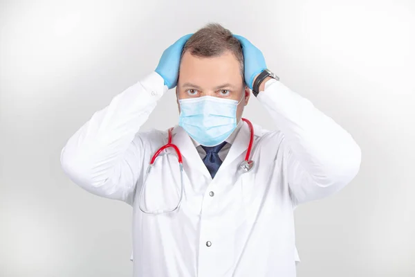Beyaz cüppeli, maskeli, steteskoplu, başını kaldıran jestli bir doktor.