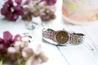 Gümüş kol saati gümüş yüzük ve cam kupa aksesuarları.