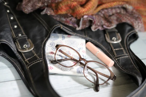 Inhalt Schwarze Lederumhängetasche Brille Lippenbalsam Und Klappspiegel Und Strickschnuller Modeartikel — Stockfoto