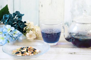 Bright blue color butterfly pea flower herb tea in a glass tea pot and a cup
