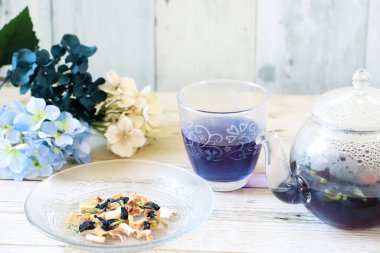Bright blue color butterfly pea flower herb tea in a glass tea pot and a cup