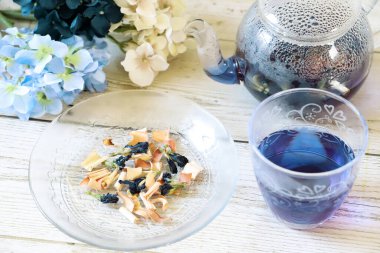 Bright blue color butterfly pea flower herb tea in a glass tea pot and a cup