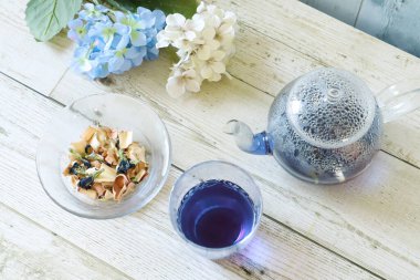 Bright blue color butterfly pea flower herb tea in a glass tea pot and a cup