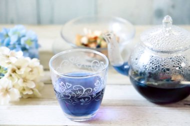 Bright blue color butterfly pea flower herb tea in a glass tea pot and a cup