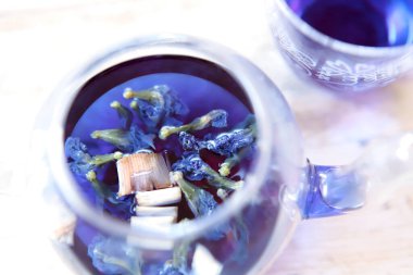 Bright blue color butterfly pea flower herb tea in a glass tea pot and a cup