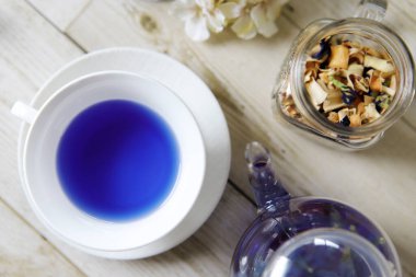 Bright blue color butterfly pea flower herb tea in a glass teapot and a teacup