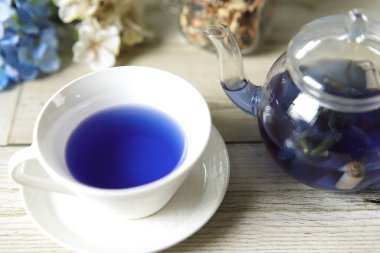 Bright blue color butterfly pea flower herb tea in a glass teapot and a teacup