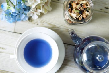 Bright blue color butterfly pea flower herb tea in a glass teapot and a teacup