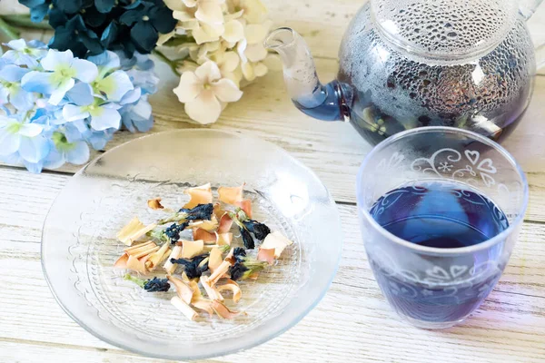 Bright blue color butterfly pea flower herb tea in a glass tea pot and a cup
