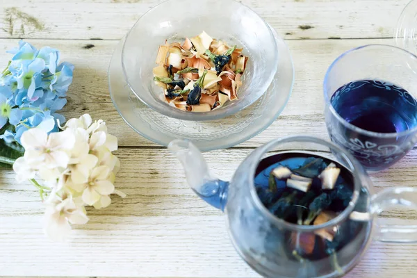 Bright blue color butterfly pea flower herb tea in a glass tea pot and a cup