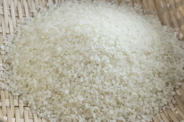 Polished rice in a bamboo basket — Zdjęcie stockowe