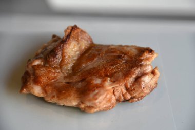 Grilled juicy peace of meat on simple gray background with reflection