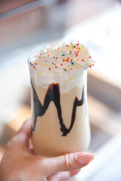 Yakın plan, lezzetli milkshake 'i tutuyor.