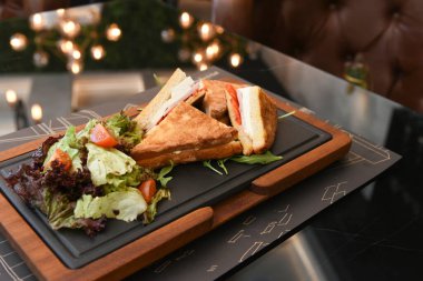  Jambonlu ve salatalı leziz kızarmış yumurta. İki el bıçak ve çatal, iki kişi yemek yiyor.