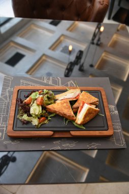  Jambonlu ve salatalı leziz kızarmış yumurta. İki el bıçak ve çatal, iki kişi yemek yiyor.