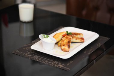  Jambonlu ve salatalı leziz kızarmış yumurta. İki el bıçak ve çatal, iki kişi yemek yiyor.